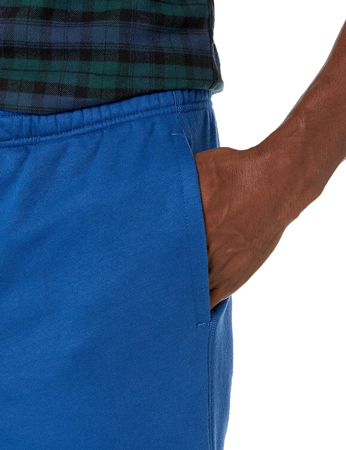 Mann in blauer Jogginghose mit Hand in der Tasche, kariertes Hemd, Freizeitmode.