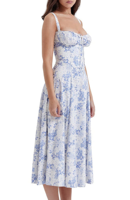 Frau in weißem, geblümtem Bustier-Sommerkleid, blaues Blumenmuster, ärmellos, knielang.