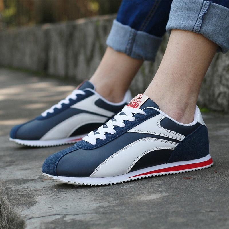 Dunkelblaue Retro-Sneaker, weißer Streifen, rote Sohle, Herrenmode, Straßenschuhe.