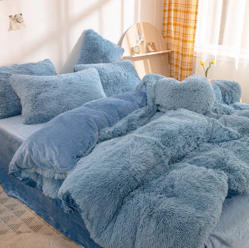 Blaue flauschige Bettwäsche-Set, Kissen und Decke, gemütliches Schlafzimmer, Tageslicht.