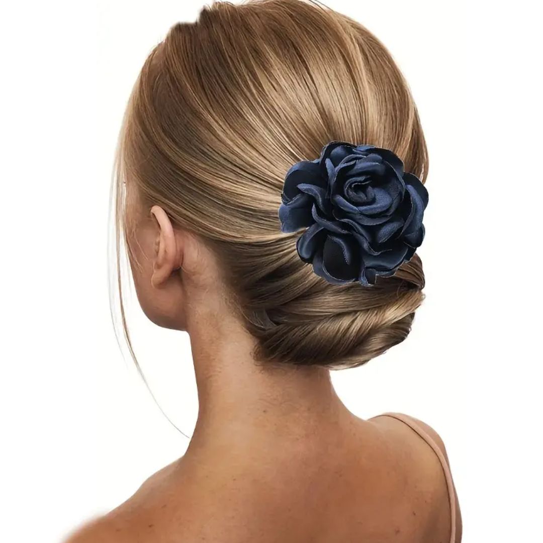 Frau mit blonden Haaren und dunkelblauer Seidenblume als Haarschmuck, eleganter Dutt.