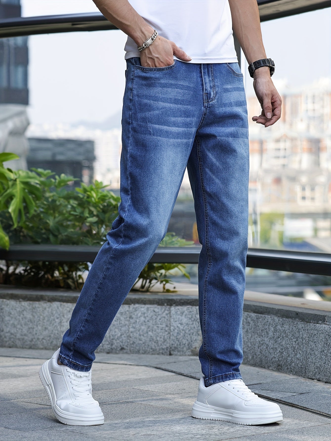 Mann in blauer Jeans und weißen Sneakers, lässige Mode, urbaner Hintergrund.