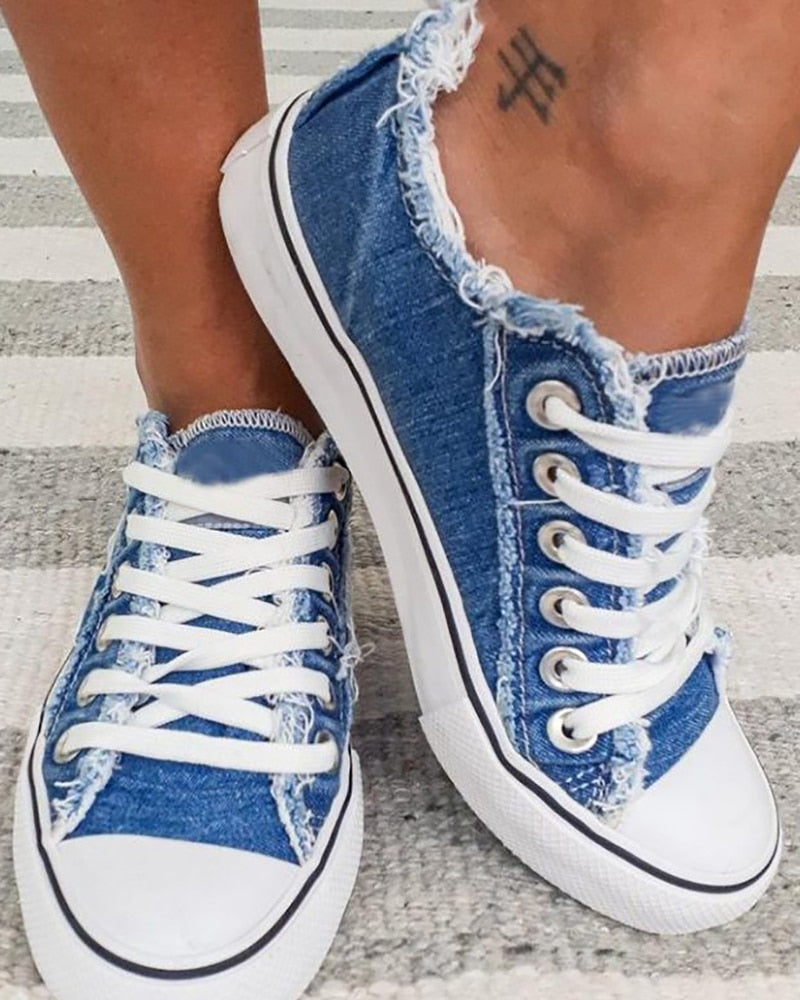 Blaue Jeans-Sneaker mit weißen Schnürsenkeln, lässiger Stil, Damenmode, Straßenmode.