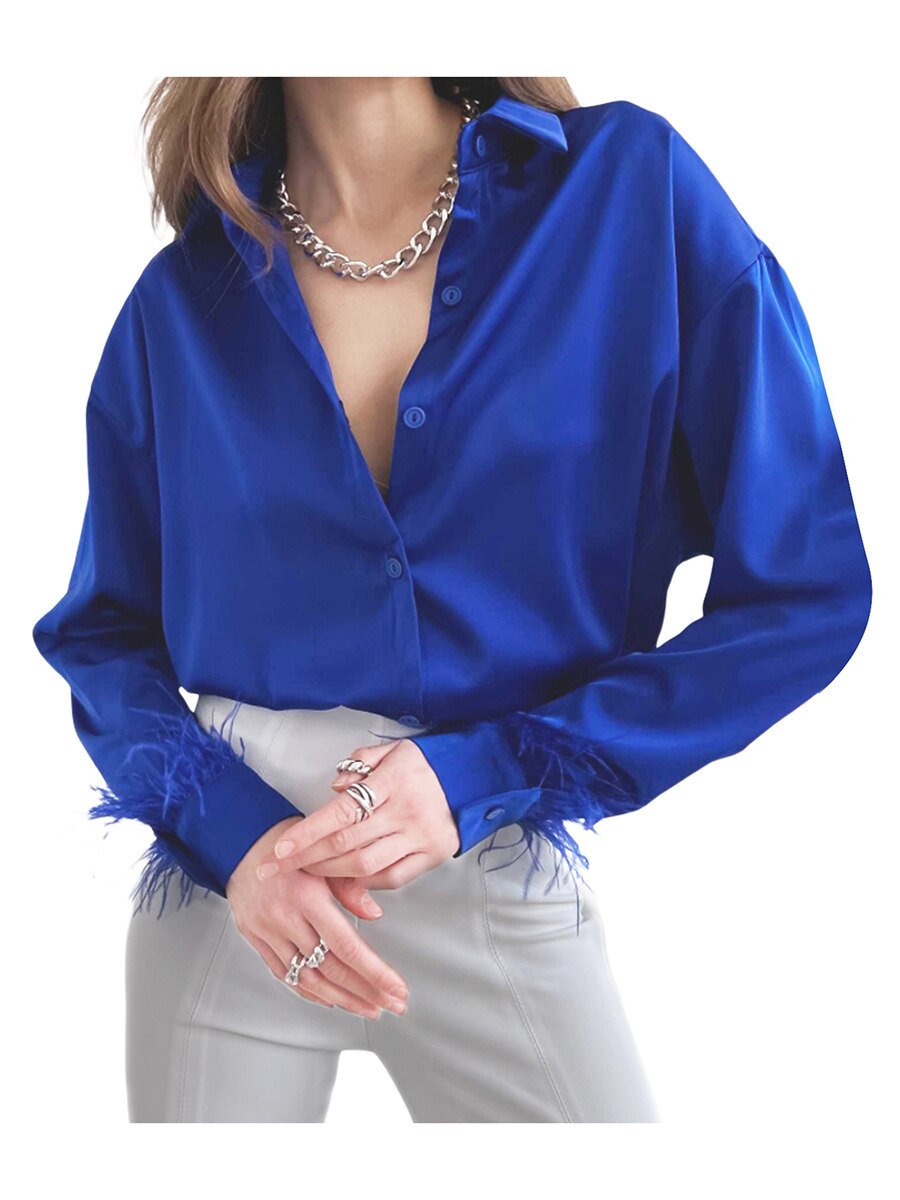 Frau in blauer Satinbluse mit Federn und silberner Halskette, modisch, elegant, Damenmode.