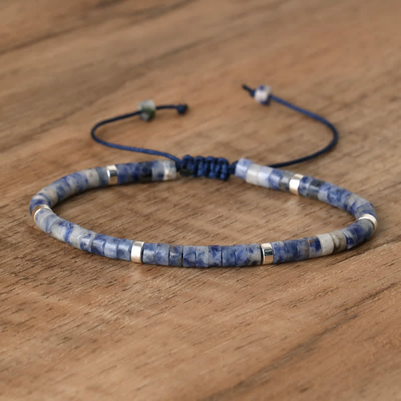 Blaues Sodalith-Armband mit silbernen Akzenten auf Holzoberfläche, verstellbar, handgefertigt.