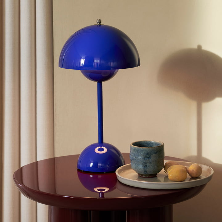 Blaue Tischlampe auf Holztisch, modernes Design, Wohnzimmerbeleuchtung, skandinavischer Stil.