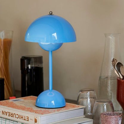 Blaue Tischlampe aus Metall auf Bücherstapel, modernes Design, Wohnzimmerdekoration.