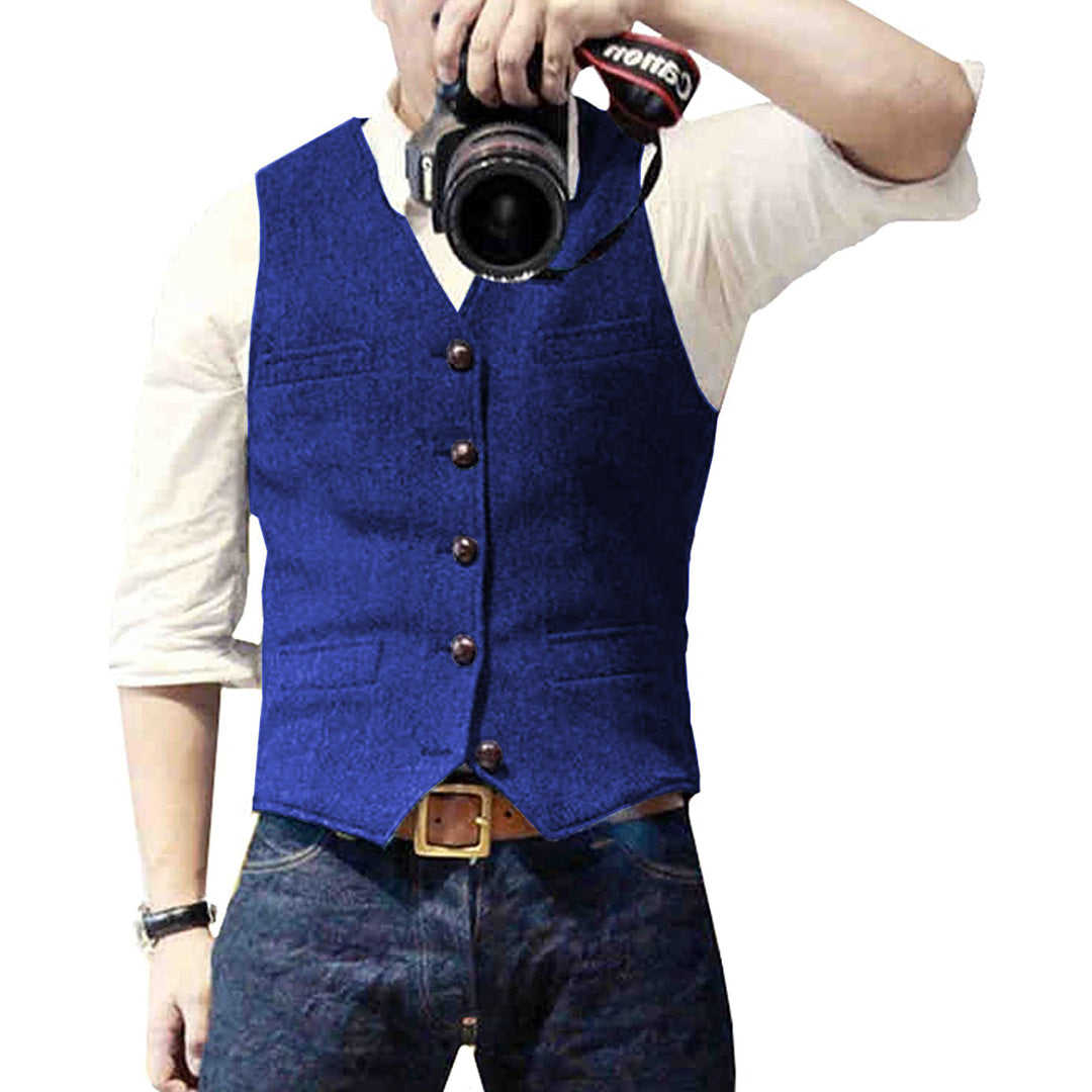 Mann mit blauer Weste, weißem Hemd, Jeans, hält Kamera, Modefotografie.