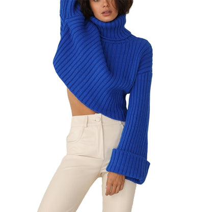 Frau in blauem Strickpullover mit Rollkragen und weißen Hosen, modisch, elegant, Herbstmode.