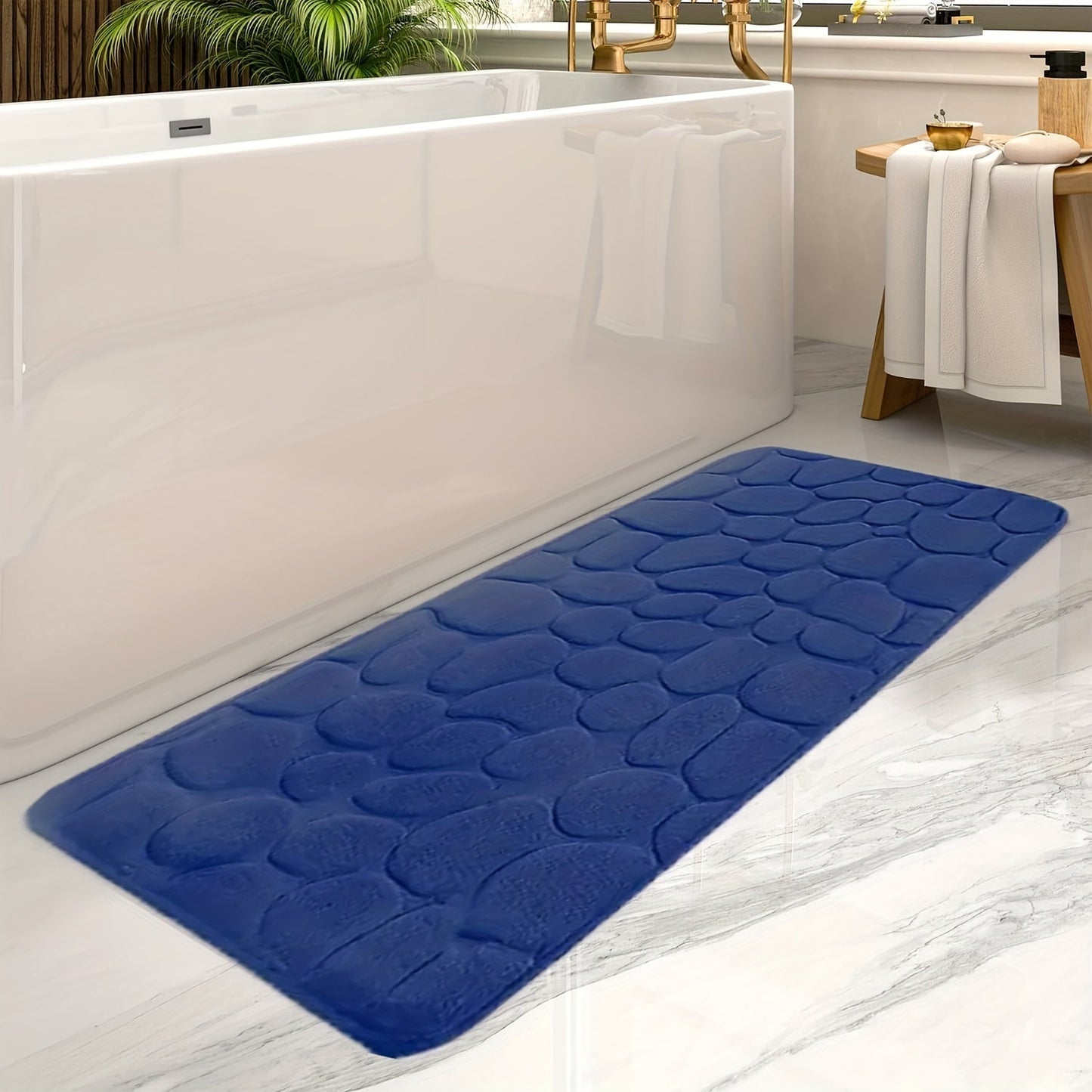 Blauer rutschfester Badezimmerteppich, Steinoptik, vor weißer Badewanne auf Marmorboden.