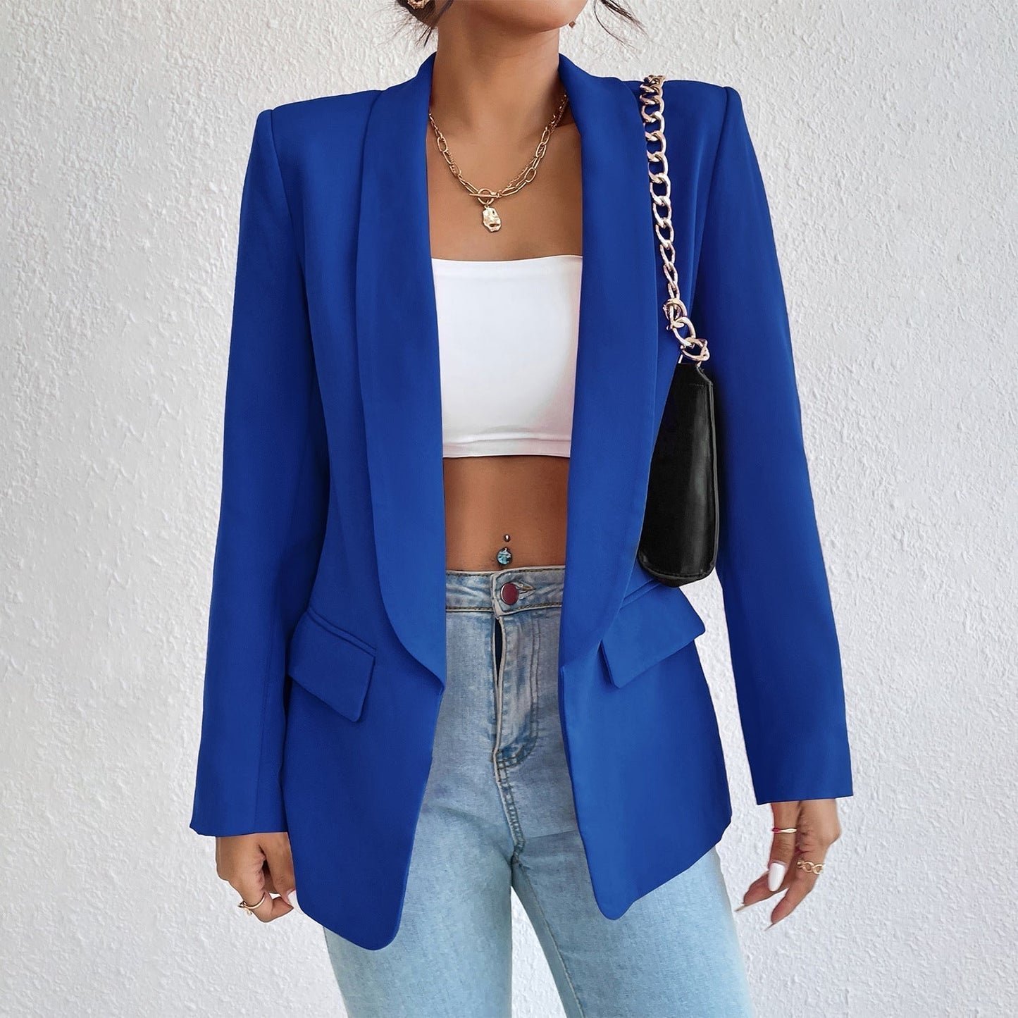 Frau in blauem Blazer, weißem Top, Jeans, schwarze Tasche, modisch, elegant, Damenmode.