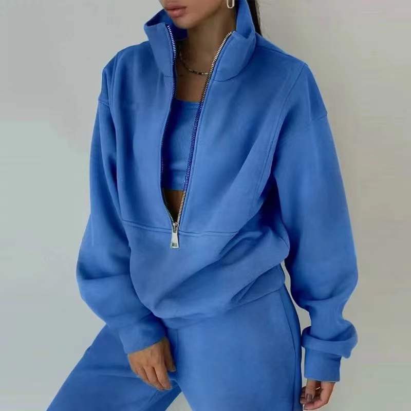 Frau in blauem Trainingsanzug mit Reißverschluss, Sportmode, Freizeitkleidung, Fitness-Outfit.