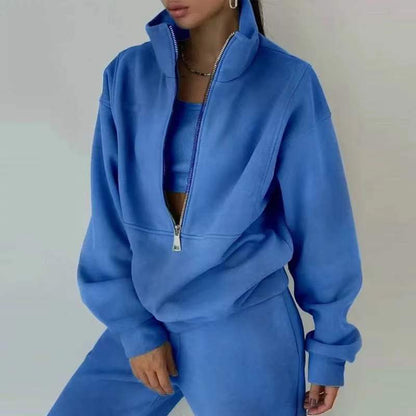 Frau in blauem Trainingsanzug mit Reißverschluss, Sportmode, Freizeitkleidung, Fitness-Outfit.