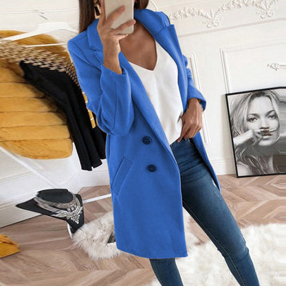 Frau im blauen Mantel, weiße Bluse, Jeans, modernes Wohnzimmer, Modefotografie.