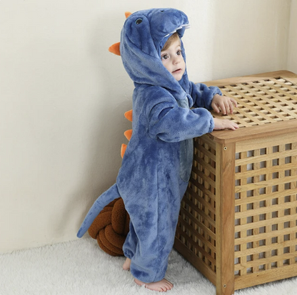 Kleinkind im blauen Dinosaurier-Kostüm mit Kapuze und orangefarbenen Stacheln, Plüschmaterial.