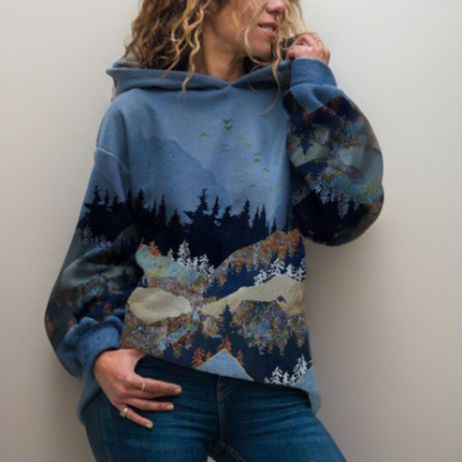 Frau in blauem Hoodie mit Berglandschaftsdesign, lässige Mode, Herbstkleidung.