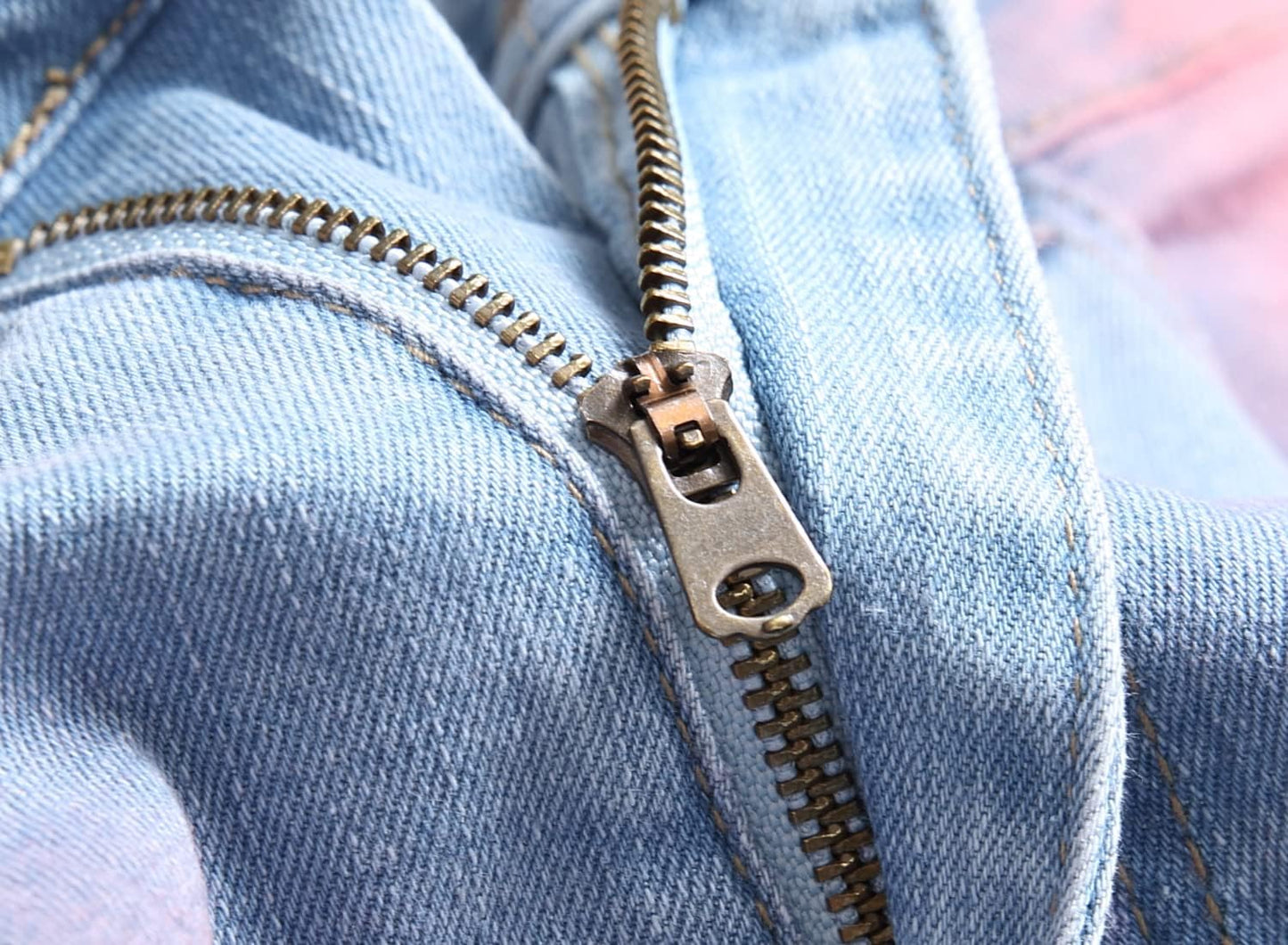 Nahaufnahme eines blauen Jeansreißverschlusses aus Metall, robust und langlebig.