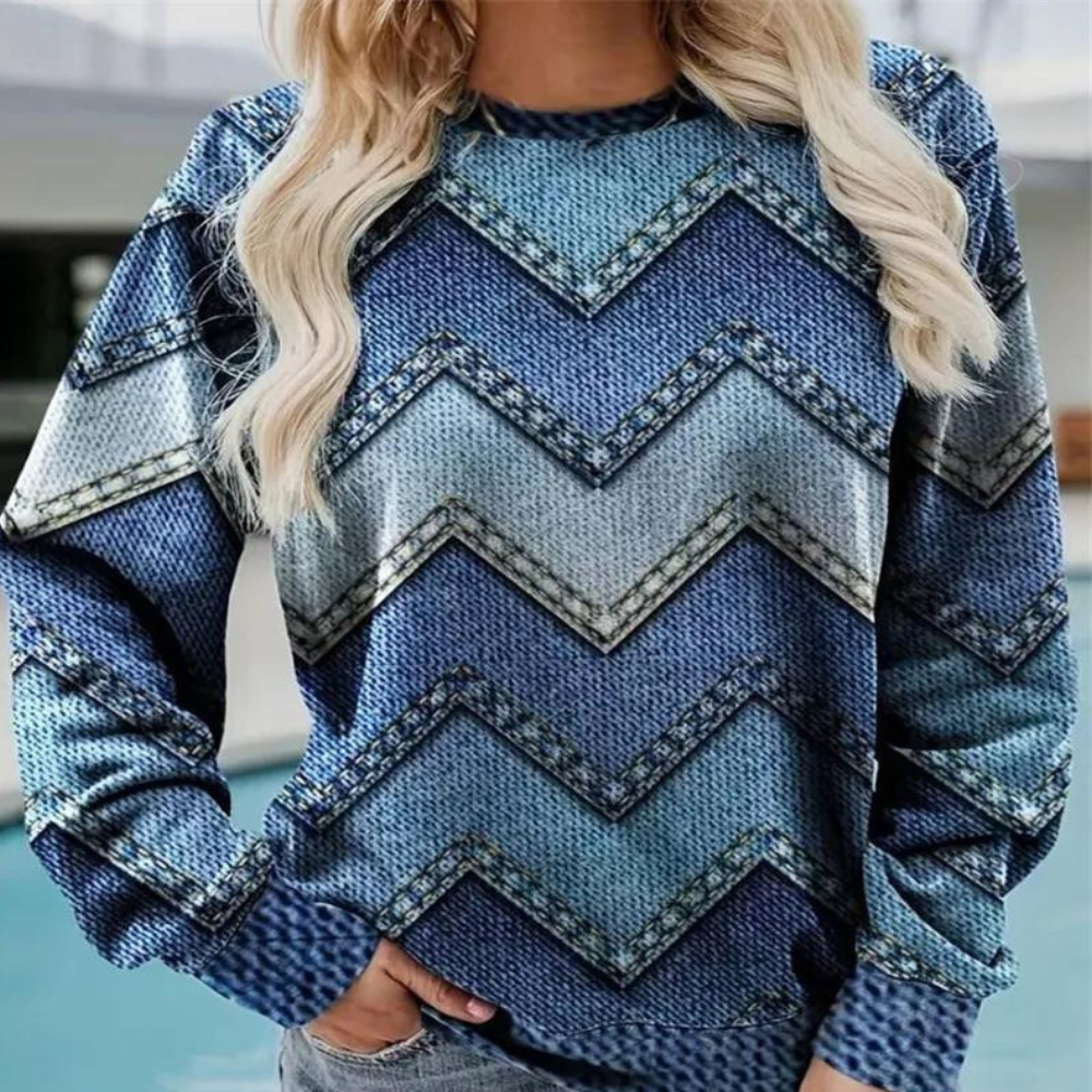 Frau trägt blauen Pullover mit Zickzackmuster, Denim-Optik, lässiger Stil, modisch.