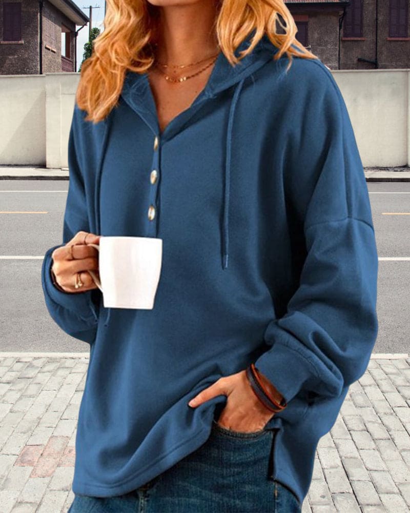 Frau in blauem Kapuzenpullover mit Kaffeetasse, lässige Mode, Herbstkleidung.