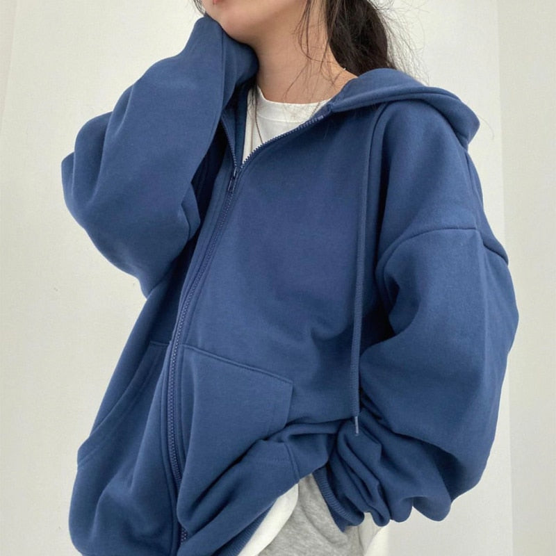 Frau in blauer Kapuzenjacke, Reißverschluss, lässiger Stil, Baumwolle, modische Damenbekleidung.