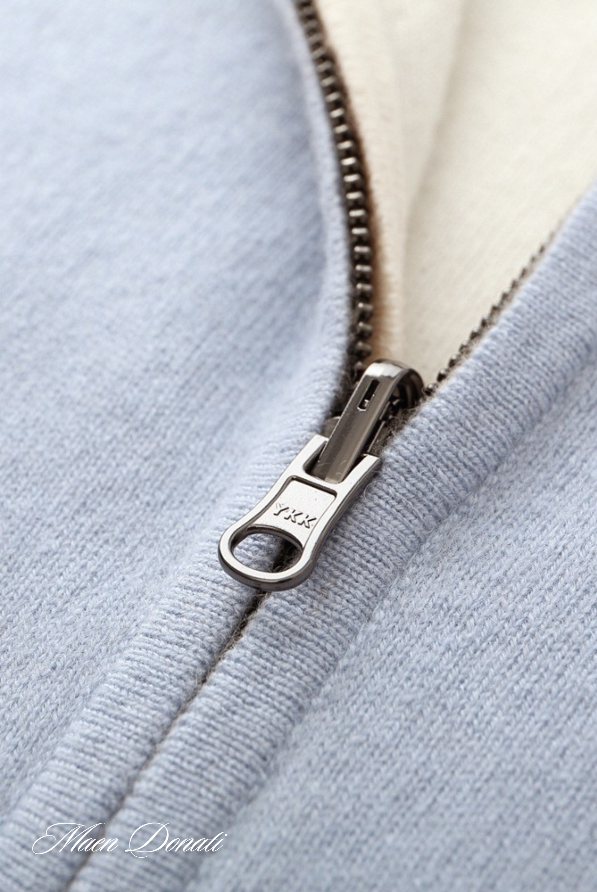 Hellblauer Reißverschluss auf Strickjacke, Nahaufnahme, Metallzipper, weicher Stoff, Modeaccessoire.