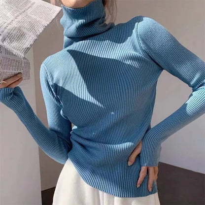 Frau in blauem Rollkragenpullover aus Strick, hält Zeitung, modisch, elegant, Herbstmode.