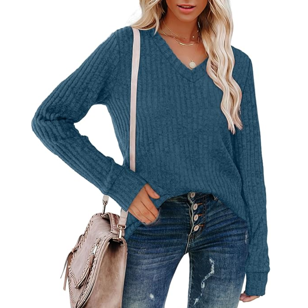 Frau in blauem Strickpullover und Jeans mit beiger Tasche, modisch, lässig, Herbstmode.