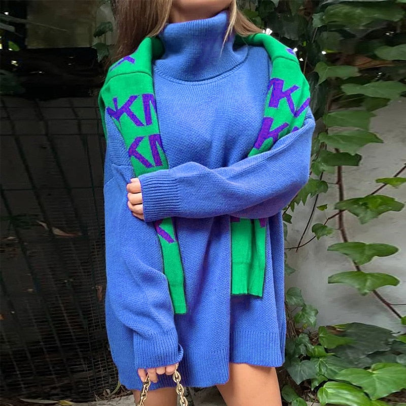 Frau in blauem Rollkragenpullover mit grünem Schal, modisch, Herbstkleidung, draußen.