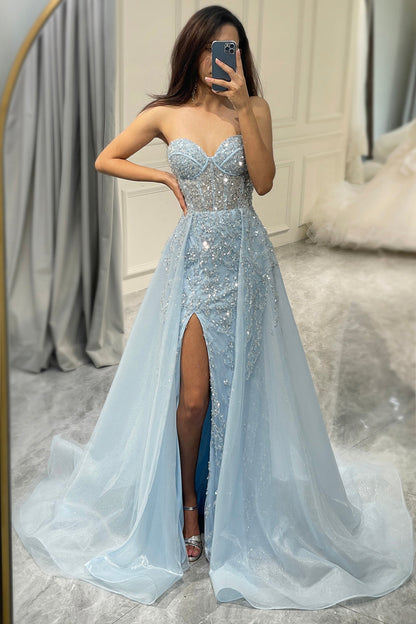 Frau im eleganten, hellblauen Abendkleid mit Pailletten und hohem Schlitz, Spiegel-Selfie.