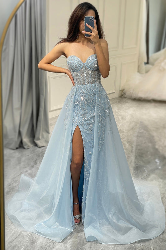 Frau im eleganten, hellblauen Abendkleid mit Pailletten und hohem Schlitz, Spiegel-Selfie.
