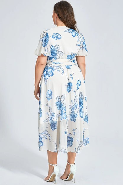 Frau in weißem Kleid mit blauen Blumen, Plus-Size, Rückansicht, Sommermode, elegante Sandalen.