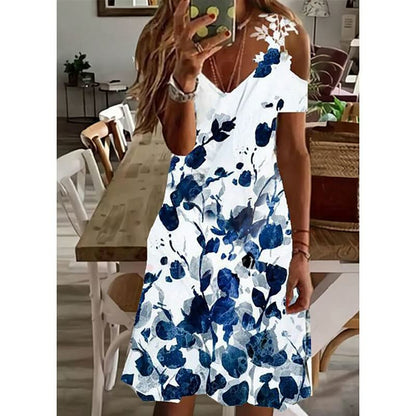 Frau in weißem Sommerkleid mit blauen Blumenmuster, schulterfrei, im modernen Esszimmer.