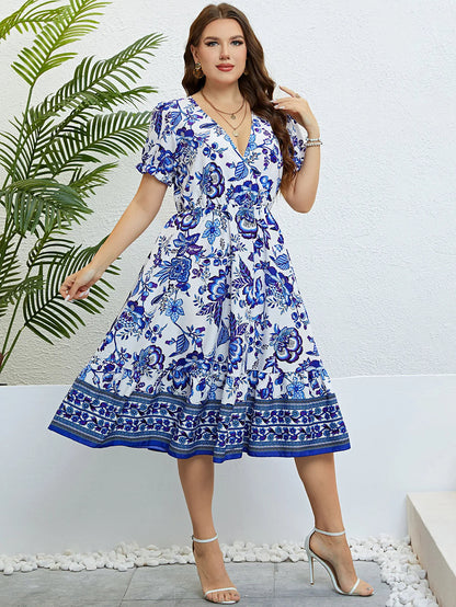 Frau im blauen Blumen-Sommerkleid, V-Ausschnitt, knielang, elegante Mode, draußen.