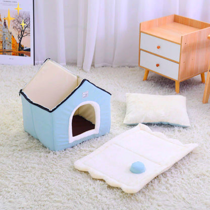 Blaue Hundehütte aus Stoff auf weißem Teppich, mit Kissen und Spielzeug, modernes Design.