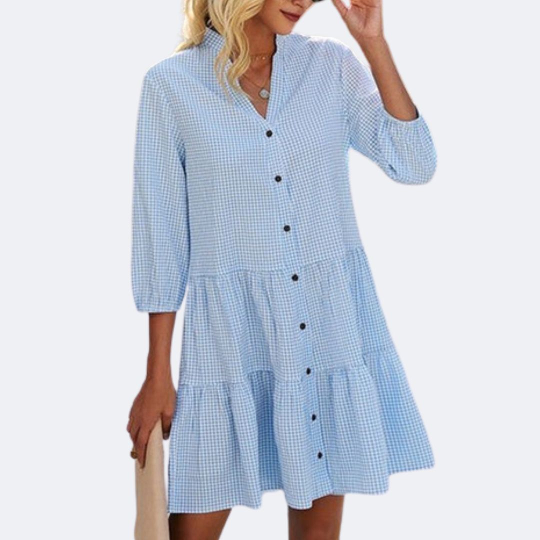 Frau in hellblauem kariertem Sommerkleid mit Knopfleiste und Dreiviertelärmeln.
