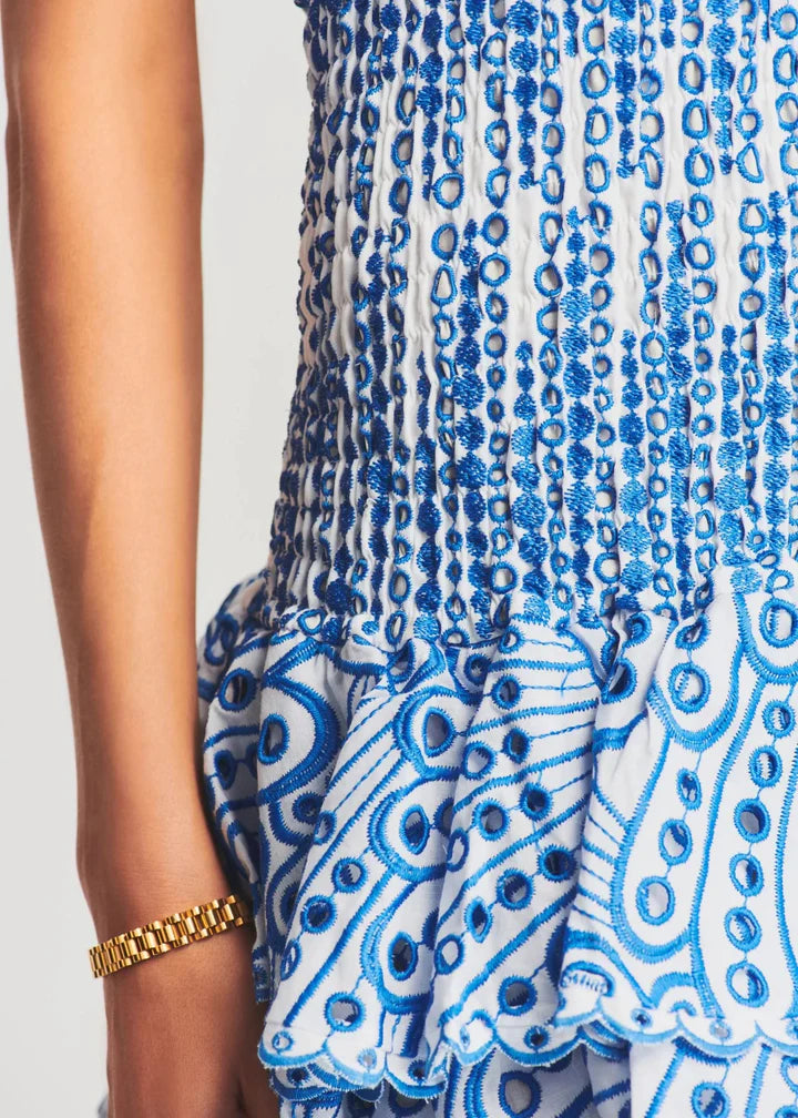 Blau-weißes Sommerkleid mit Rüschen und goldfarbenem Armband, elegantes Design, Damenmode.