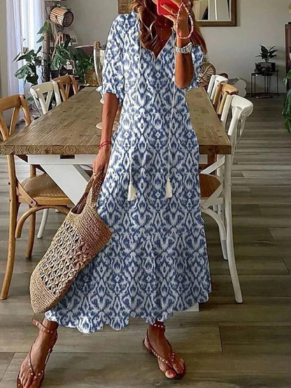 Frau in blau-weißem Sommerkleid mit Korbtasche im Esszimmer.