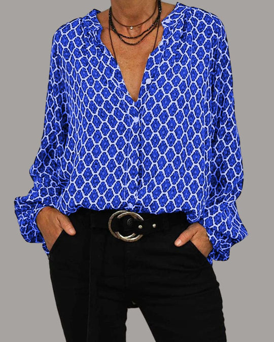 Frau in blauer gemusterter Bluse und schwarzer Hose mit Gürtel, modisch, lässig, elegant.