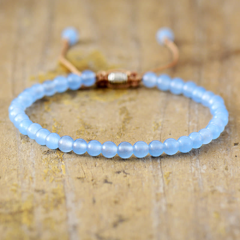 Blaues Perlenarmband aus Glas auf Holzoberfläche, verstellbar, handgefertigt, modisch.