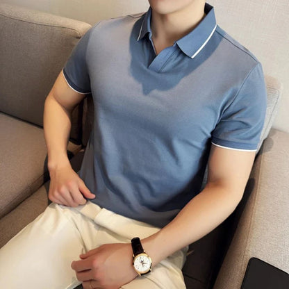 Mann in blauem Polohemd und weißer Hose auf Sofa, Armbanduhr, Freizeitmode.
