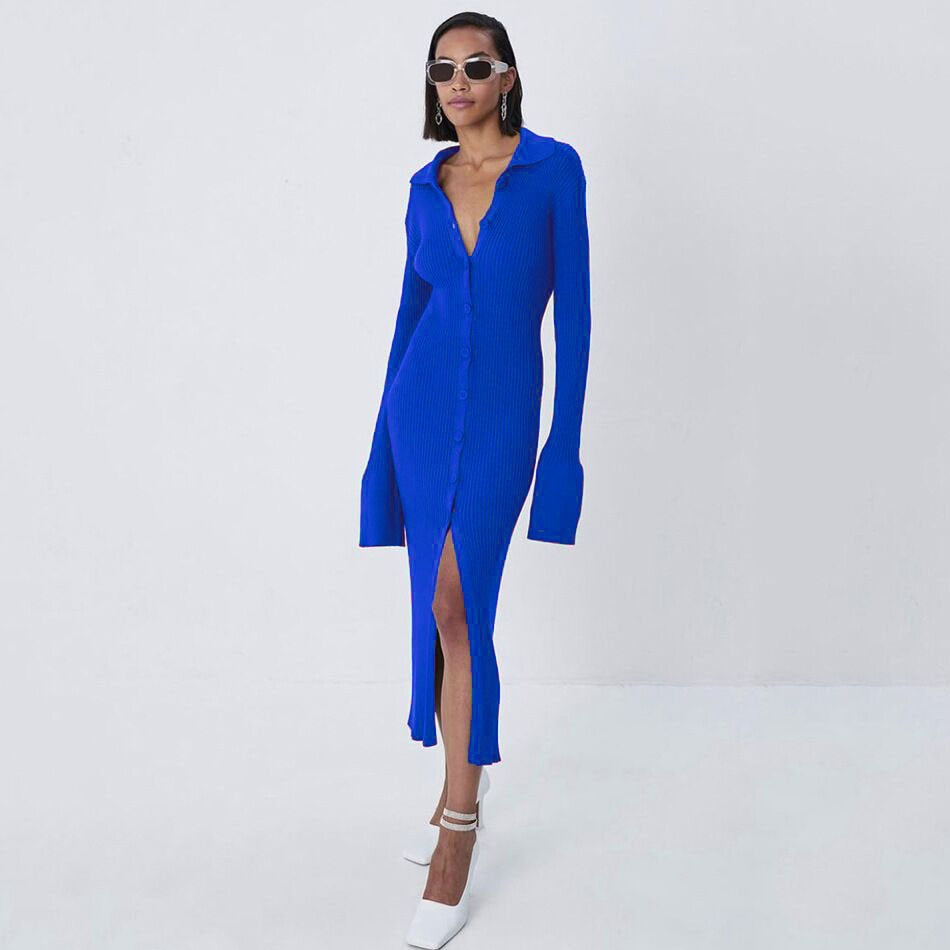 Frau in blauem Strickkleid mit Knopfleiste und Schlitz, trägt weiße Schuhe und Sonnenbrille.