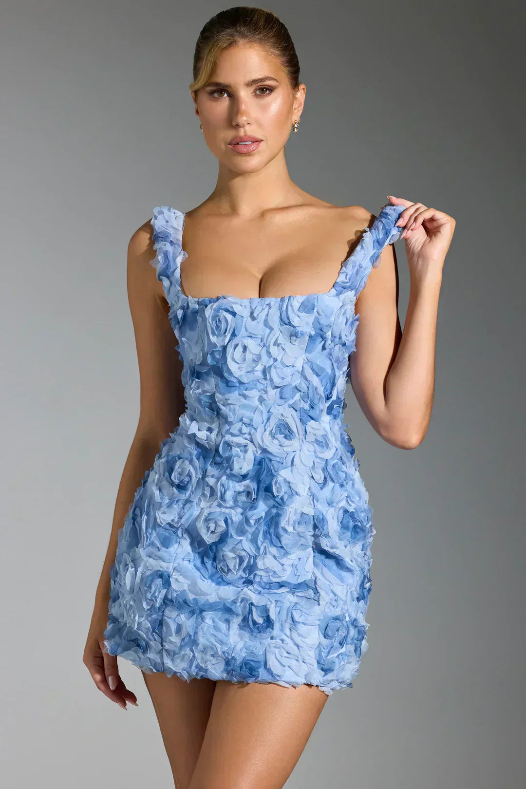 Blaues Minikleid mit Blumenmuster, ärmellos, elegantes Design, ideal für Partys und Events.