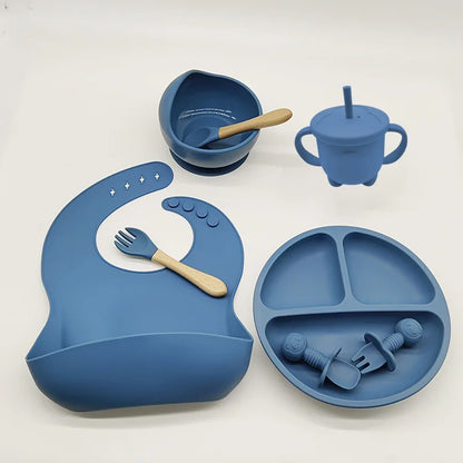 Blaues Silikon-Babygeschirr-Set mit Lätzchen, Teller, Schüssel, Becher und Besteck.