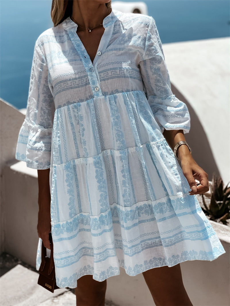 Frau in weiß-blauem Sommerkleid mit Muster, am Meer, lässiger Stil, Urlaubskleidung.