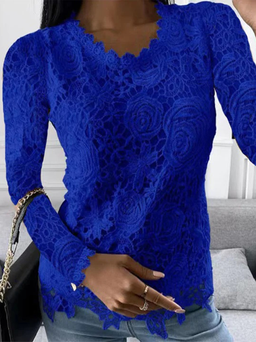 Frau in blauem Spitzenoberteil, V-Ausschnitt, lange Ärmel, modisch, elegant, Damenmode.
