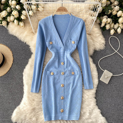 Hellblaues Strickkleid mit V-Ausschnitt, Knöpfen und Taschen, elegant und figurbetont.
