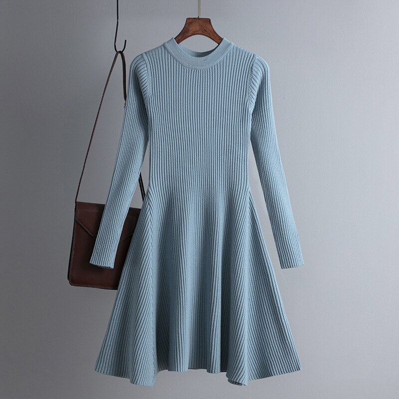 Blaues Strickkleid Damen, langärmelig, A-Linie, elegant, Herbstmode, mit brauner Tasche.
