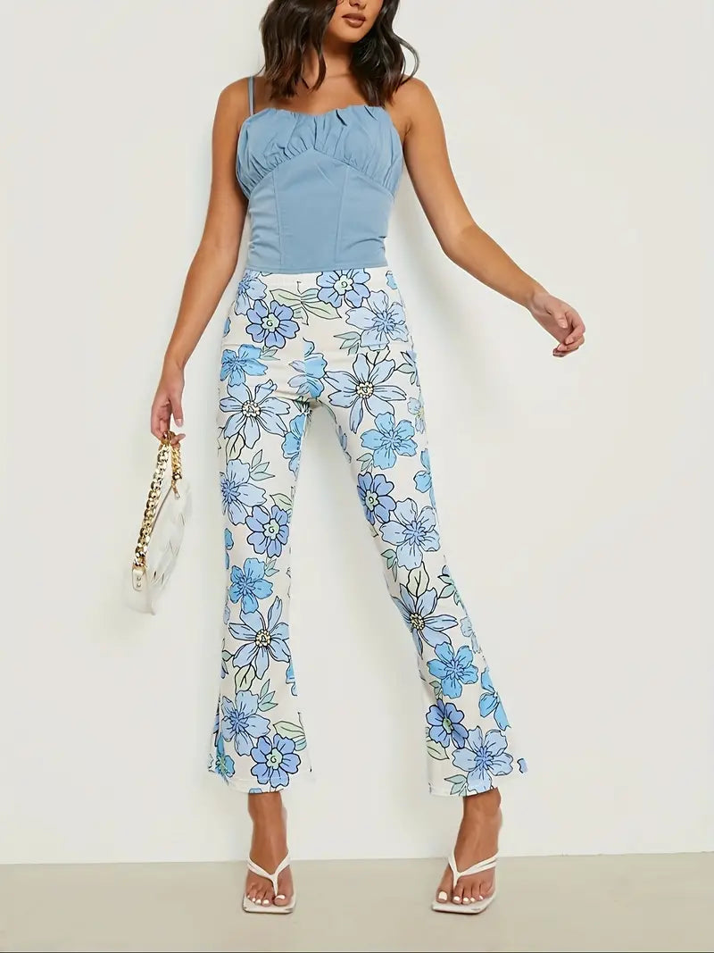Frau in blauer Bluse und weißer Hose mit blauen Blumen, modisch, Sommeroutfit, Handtasche.