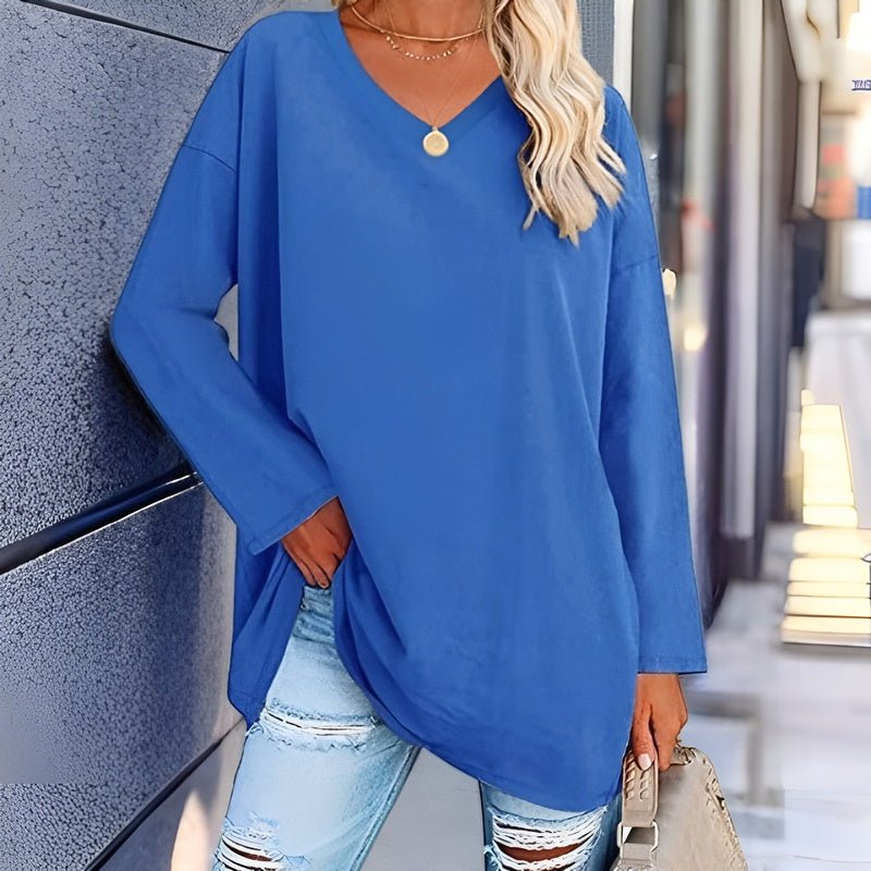 Frau in blauem V-Ausschnitt-Pullover und zerrissenen Jeans, lässige Mode, Straßenstil.