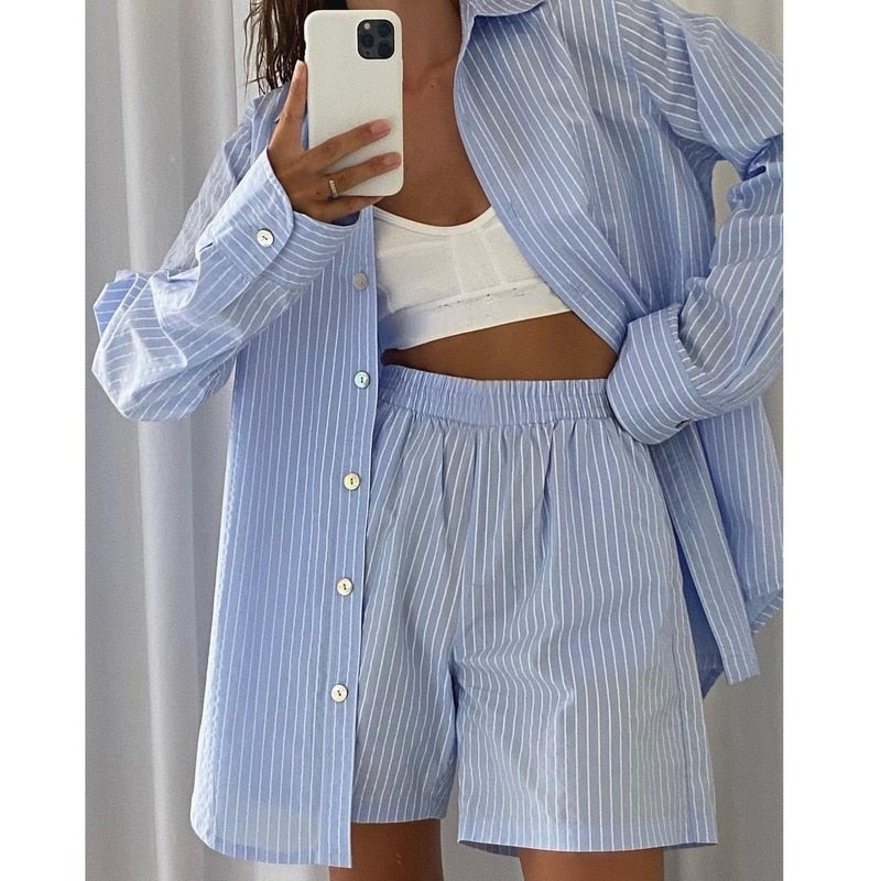 Frau in blau-weiß gestreiftem Pyjama-Set, Hemd und Shorts, Selfie im Spiegel.